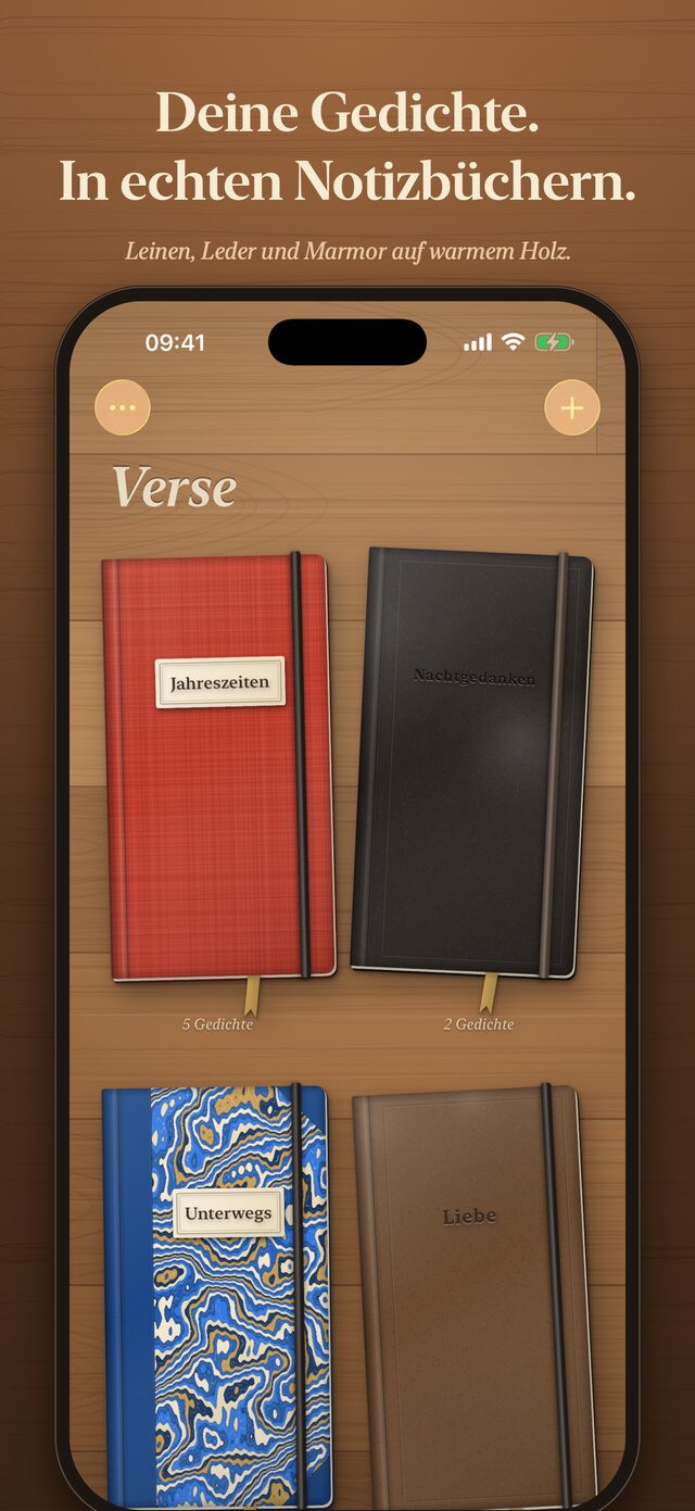 Verse auf dem iPhone: Notizbücher in Rot, Schwarz, Blau und Braun liegen auf einem Holztisch